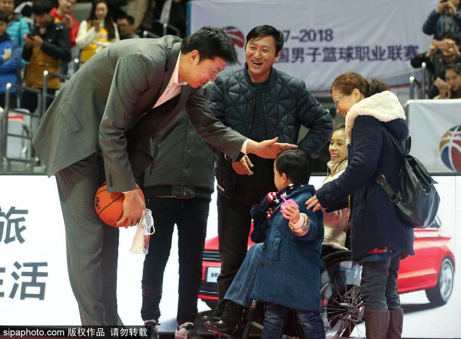 王治郅面带标志性的憨厚笑容，弯下高大身躯与轮椅上的桑兰交谈，两人眼神交汇间满是老友重逢的亲切与关怀。