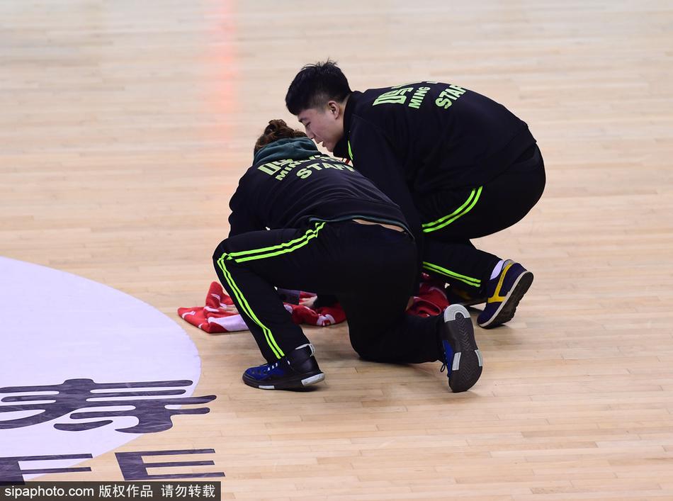 激烈的比赛间隙,辽宁队主帅郭士强布置战术,背景中是快速就位的场地清洁人员,他们共同构成了赛场内外的战斗集体