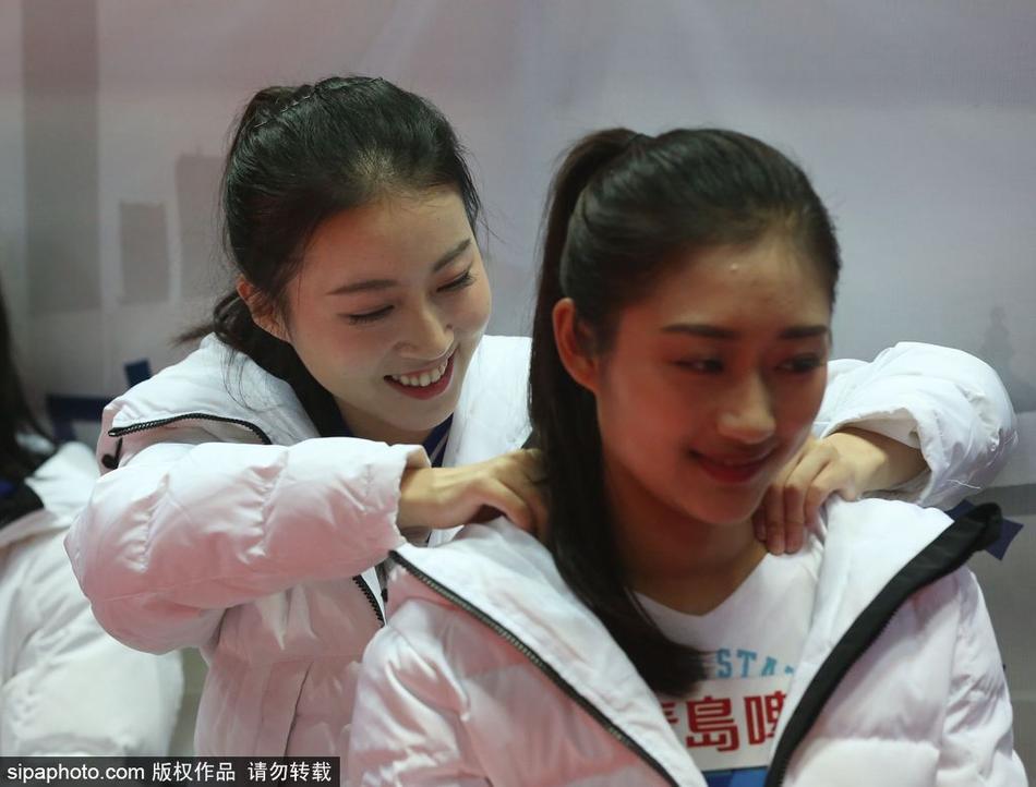 球场灯光下,一位戴着眼镜的女生正在专注地查看手机,背后是正在热身的大个子球员们。她或许是正在给无法到场的朋友发去现场的照片,分享着这份属于宁波冬夜的篮球热情。