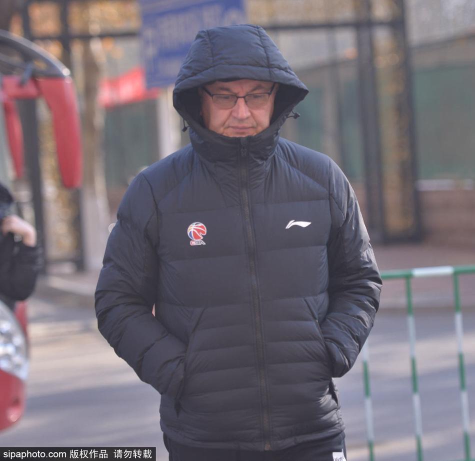 身穿蓝色训练服的易建联在山东高速球馆训练中持球，目光坚定，准备进行投篮练习。