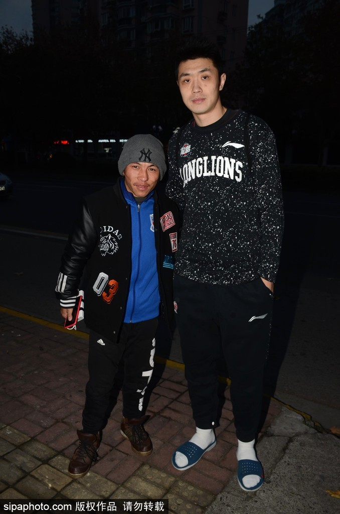 克里斯顿一手拖着行李箱，一手与球迷击掌，脸上洋溢着惊喜的笑容