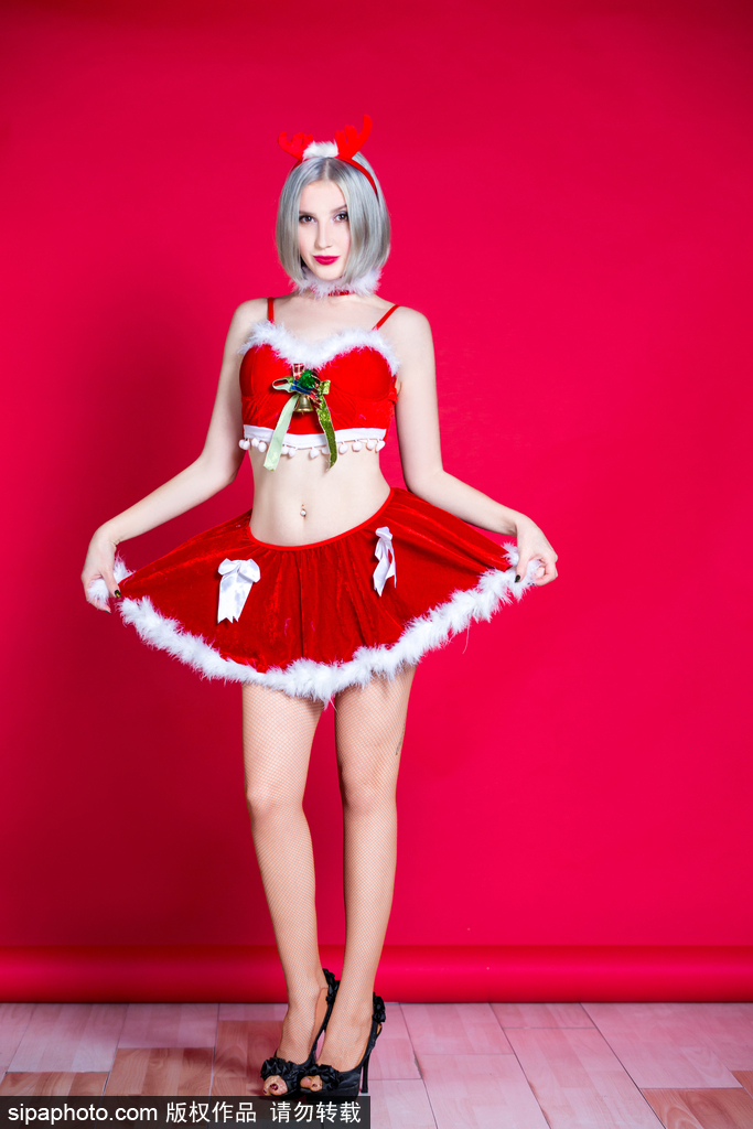 宝贝轻抚驯鹿玩偶，身姿曼妙，眼神中流露出孩童般的纯真与节日的俏皮，圣诞气息扑面而来。