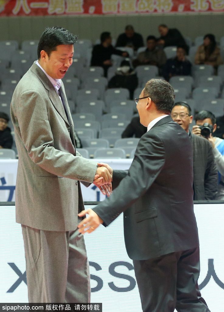 镜头拉近,捕捉到了两人交谈中最真挚的表情。范斌微微低头,眉头轻蹙,正对着大郅娓娓道来,仿佛在分享着执教福建队的心得与困惑。王治郅的面容依然俊朗温和,嘴角带着淡淡的笑意,耐心地聆听这位老大哥的诉说,两人周围仿佛形成了一个独立于喧嚣赛场之外的安静世界。