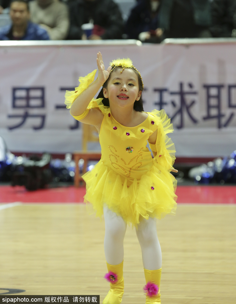 侧拍镜头下,一名萌娃啦啦队员高高举起手中的彩球,仰头看向空中的花球,眼神中充满好奇与星光,上扬的嘴角透露出表演带来的纯粹快乐。