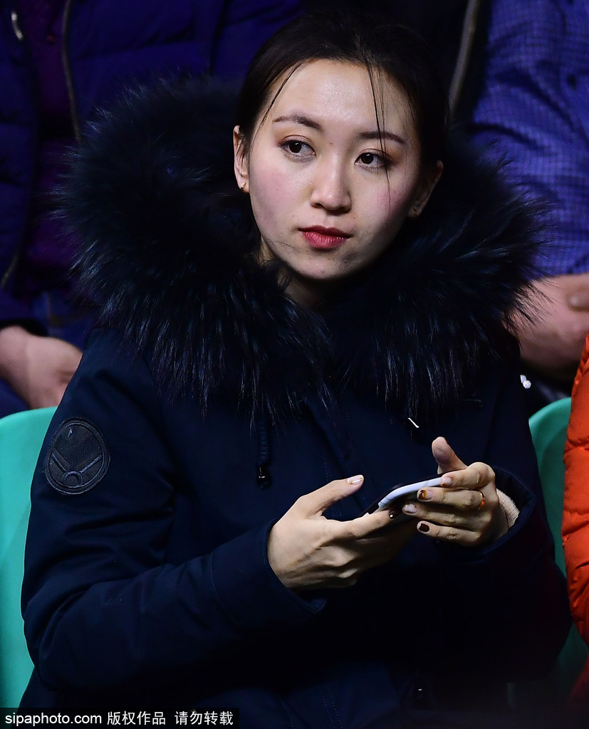 镜头拉近,这位戴着黑框眼镜的知性美女在人群中格外显眼。她微微侧身,嘴角扬起一抹恬淡的微笑,似乎在和朋友讨论着刚才场上发生的激烈对抗,那份从容与优雅与球馆内的喧嚣形成了一种奇妙的反差。