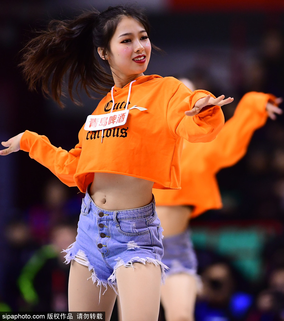 篮球宝贝们身着红白相间的劲装，马尾辫随着动感的鼓点有力甩动，她们张开双臂，用最灿烂的笑容迎接入场观众，仿佛冬日里的一把火。