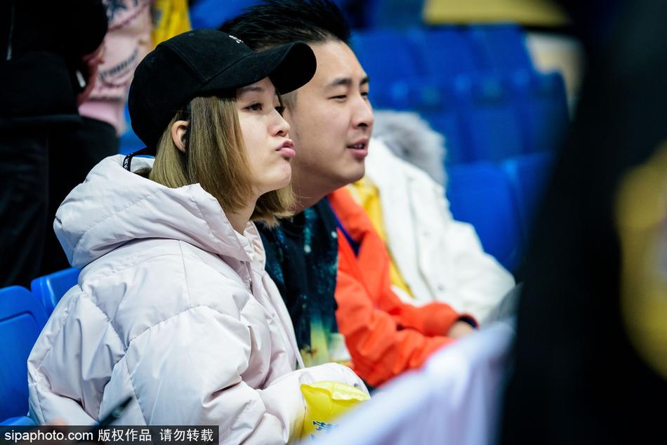 在比赛暂停间隙，这位容貌姣好的女球迷低头查看手机，或许是在与朋友分享此刻激动的心情，又或是错过了男朋友发来的信息，专注的神情里藏着少女的心事。