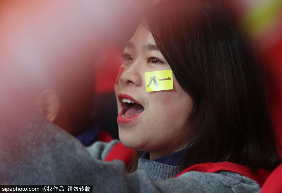 一位长发披肩的八一美女球迷，在寒夜里身着单薄的助威服，眼神中充满对球队赛季首胜的渴望，双颊因激动而微微泛红。