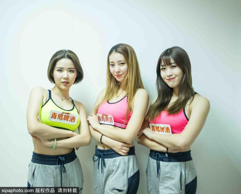 出发前的最后集结，篮球宝贝们将手叠放在一起，齐声高喊加油口号。身后的衣架上挂满了色彩鲜艳的表演服，如同她们即将为赛场涂抹上的亮丽色彩。