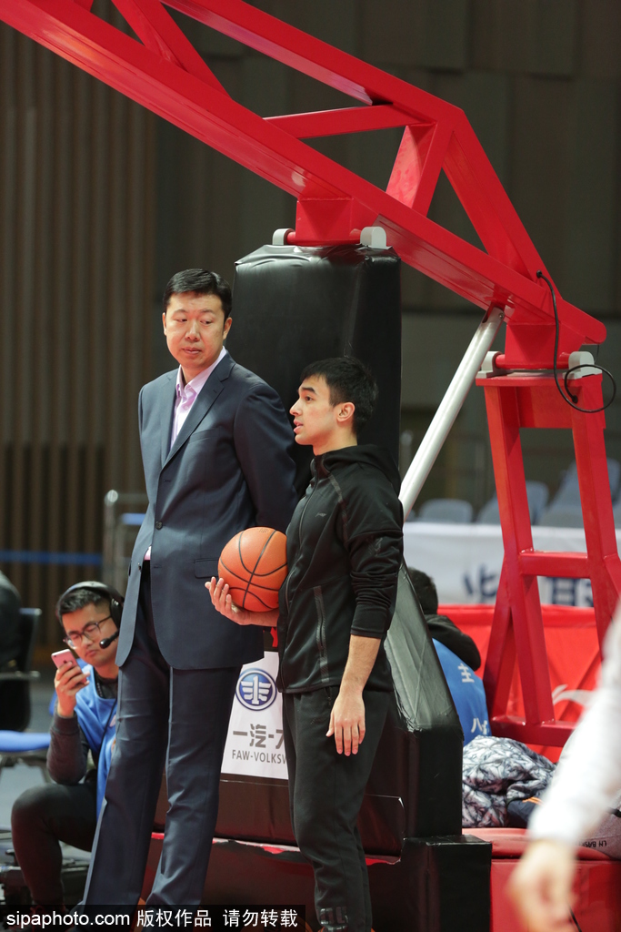 身穿蓝色卫衣的王治郅双手抱在胸前,目光专注如炬,仿佛要将场上每一位球员的热身细节都镌刻在心里,场边的他虽静默伫立,却自带一种定海神针般的气场。