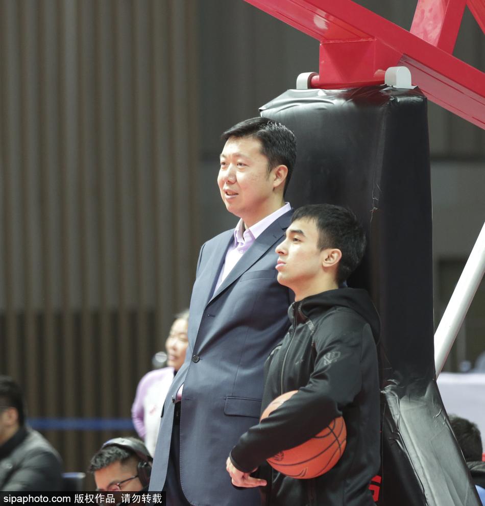 大郅侧身而立,仿佛与身边的好友低声交流着场上的局势,嘴角挂着一丝淡淡的微笑,那笑容里饱含着对篮球纯粹的爱与对后辈的无限包容。