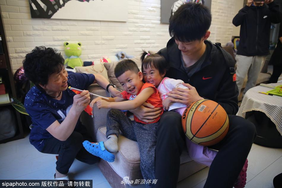 身穿白色国家队队服的胡金秋，带着标志性的腼腆笑容，双手将大红色的球票递给球迷家的男主人，两人目光交汇，仿佛多年老友重逢。