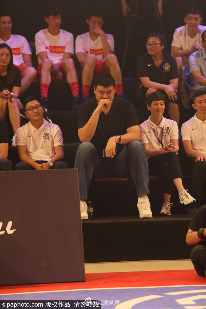 姚明双手交叉认真观看场上的扣篮表演，神情专注仿佛在思考着中国三人篮球的战术未来