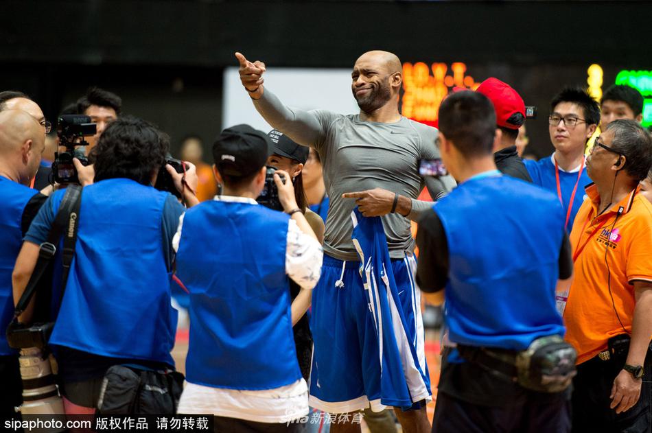 文斯·卡特持球突破，尽管已年届四十，但他的动作依然舒展飘逸，面对中国队的防守，他眼神坚定，随时准备起飞，将昔日的扣篮风采带到了香港的赛场。