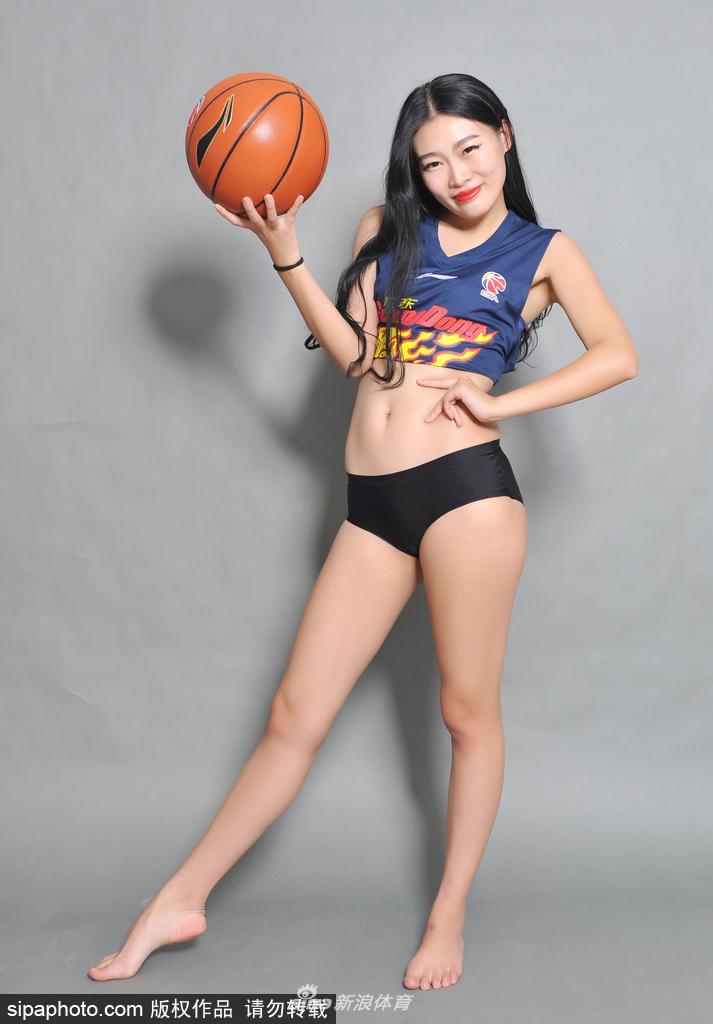 篮球宝贝单手叉腰立于光影之中，眼神坚定展现自信风采