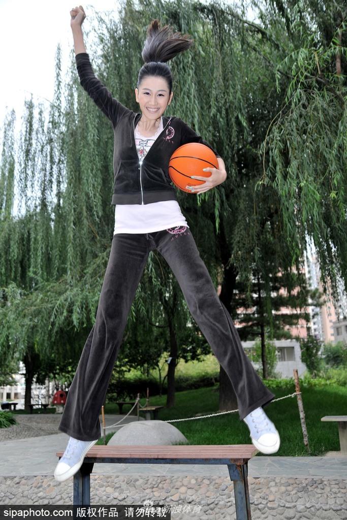 梁燕燕手举篮球轻盈跃起，纯真笑容洋溢在脸上，篮球服勾勒出修长身姿，仿佛将夏日的活力定格在空中。