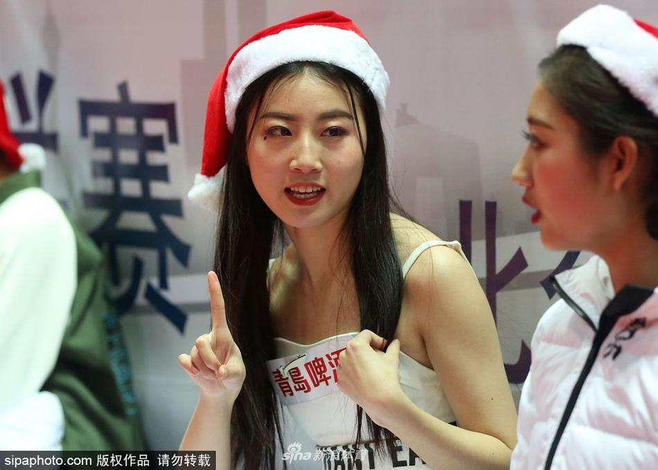 镜头转向另一侧，宝贝们围成一圈对着手机镜头比出可爱的剪刀手，背景是雅戈尔体育馆的看台和正在热身的八一队员，一张完美的打卡照就此诞生。