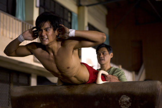 少年彭于晏戴著黑框眼鏡留著呆萌西瓜頭，圓潤的下巴和粗壯的大腿顯得格外可愛，躲在鏡頭後方露出羞澀微笑。