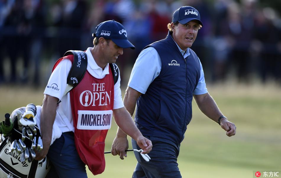 麦克罗伊与同组的达斯汀·约翰逊在球道上并肩前行，两人表情严肃，似乎都在反思首轮比赛的得失，空气中弥漫着竞争与尊重的复杂气息。