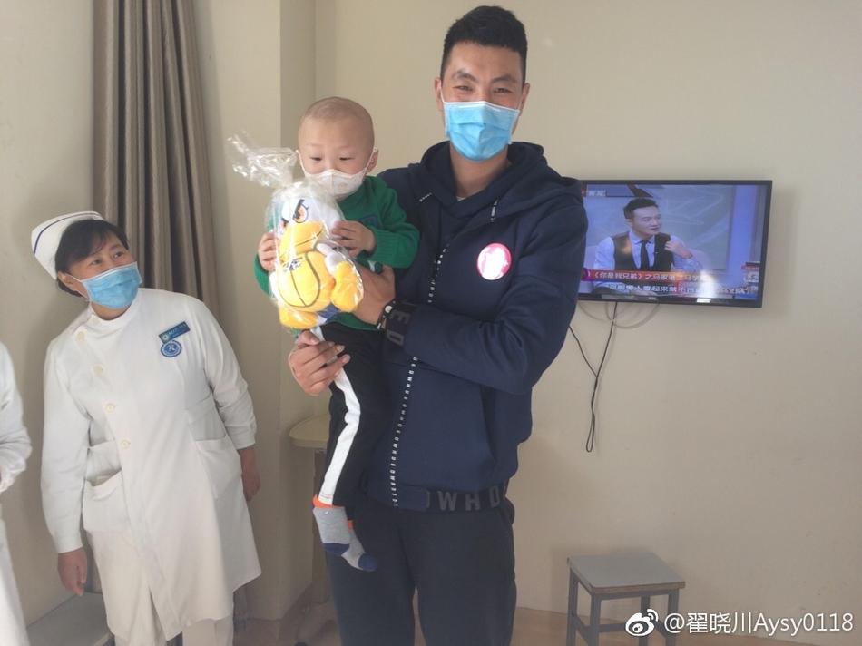 病房的活动区内，翟晓川和队友张松涛陪伴在孩子们身边，大家围坐在小桌子旁，聚精会神地拿着画笔在画纸上涂抹色彩，共同创作他们心中的篮球梦想。