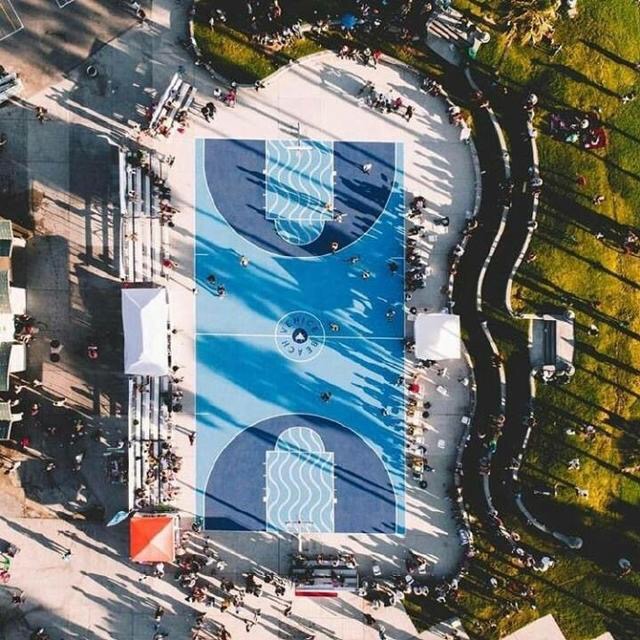 海边的渐变色篮球场，蓝色从浅至深，仿佛与天空海水连成一线