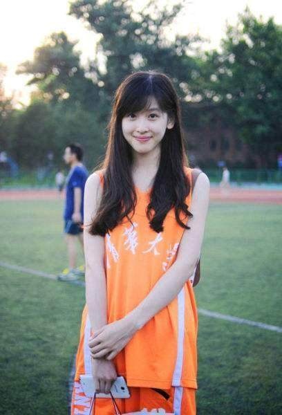 女孩高高束起马尾，身着篮球背心惬意地靠在沙发上，一手随意搭在膝上，姿态放松，尽显运动少女的元气与居家时刻的自在悠闲。