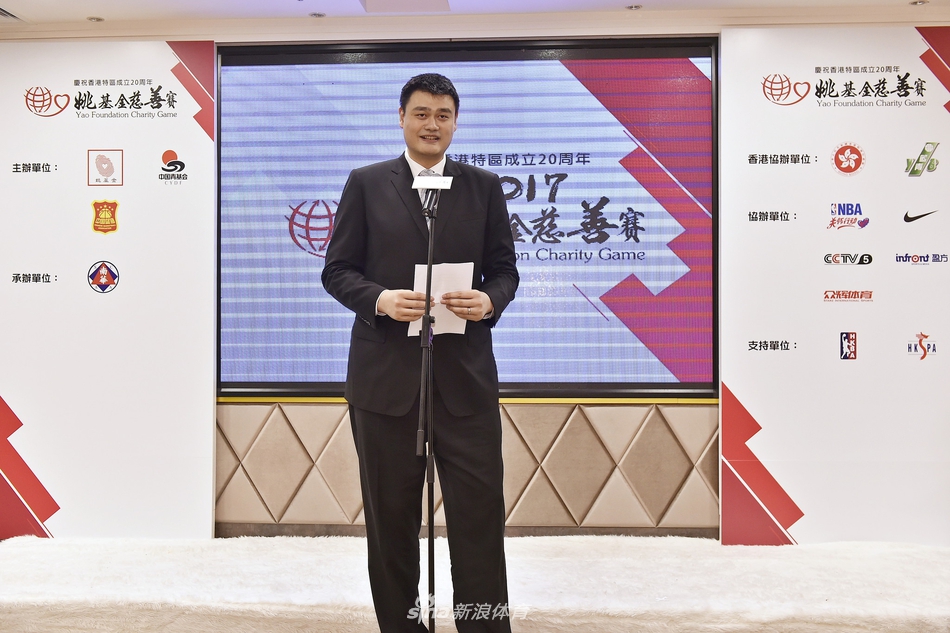 在活动现场的合影环节，姚明与众人一起登上台阶，他高大的身影格外引人注目，正以标志性的微笑配合摄影师完成大合影。