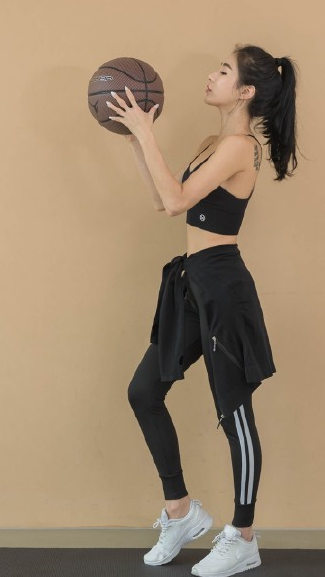 双手抱球的她站在三分线外,目光如炬地凝视着篮筐。紧身的运动背心勾勒出她纤细有力的腰肢,修长的双腿充满力量感,随时准备启动突破。