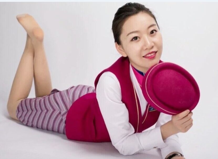 赛场边的空姐篮球宝贝侧身而立，紧身的白色运动上衣勾勒出完美身形，她专注的眼神中充满了对比赛的期待。