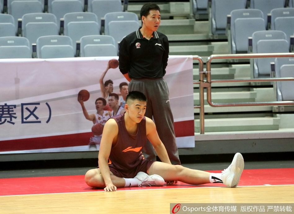 训练间隙，王治郅亲自捡起滚落到场边的篮球，准备为年轻队员们进行一对一的内线脚步示范，场边的队友们都在期待这次教学。