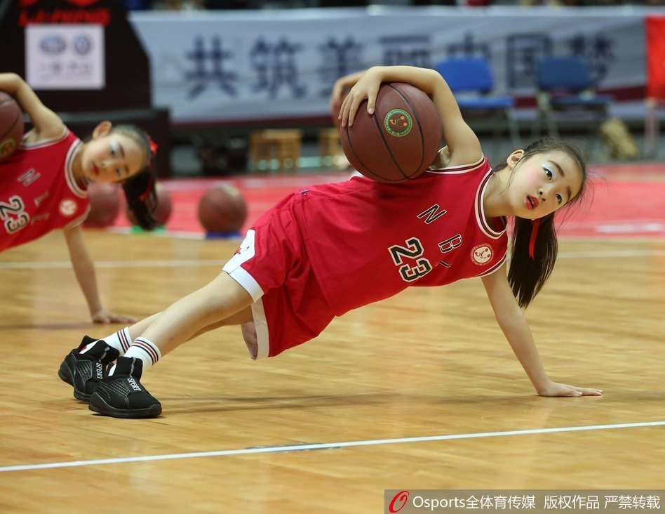 一名小球员在人群中灵巧地将球挑起,准备进行过人,周围防守球员的眼神中充满了惊讶与无奈,画面充满了童趣与竞技的张力。