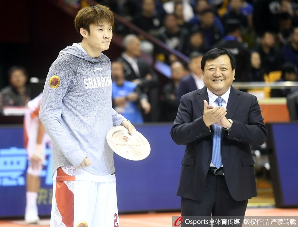 聚光灯下的丁彦雨航神情专注，汗水浸湿了他的球衣，胸前的队徽在灯光下熠熠生辉，见证着他对胜利的渴望与执着。