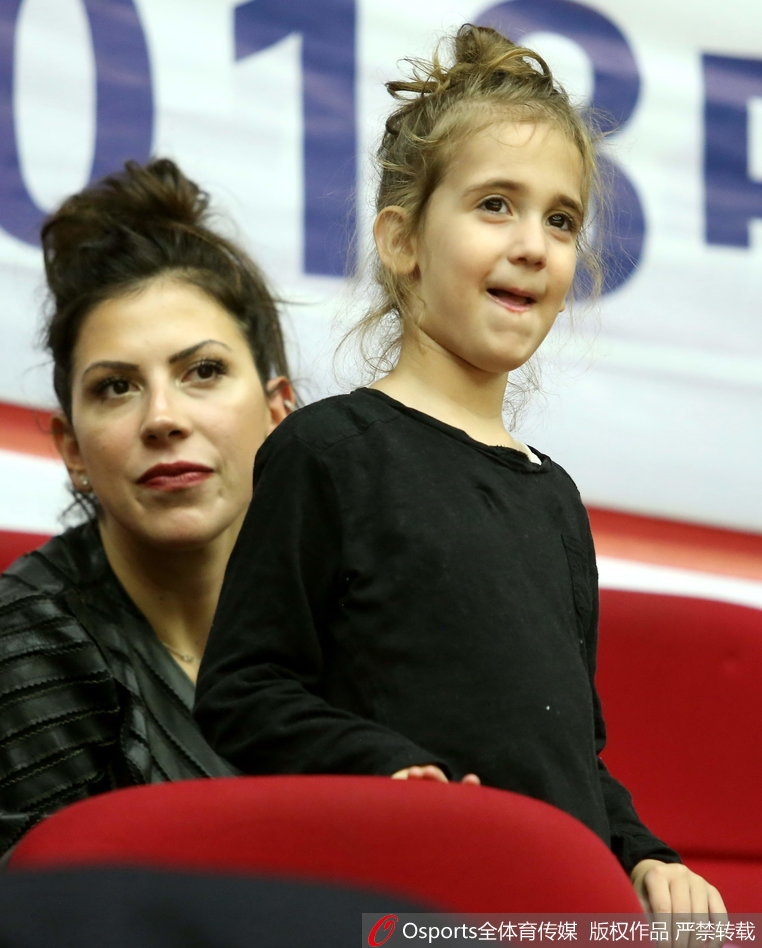 博洛西斯妻子抱着女儿在场边观战,她们穿着温馨的便装,在嘈杂的球馆中为场上的家人默默祈祷。