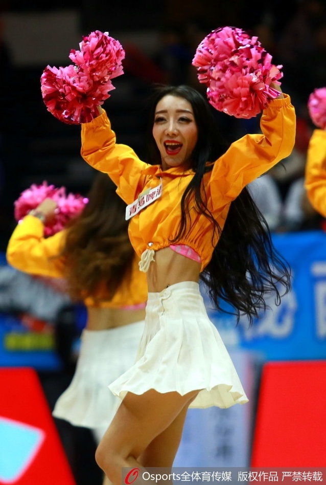 特写镜头下，一位篮球宝贝笑容灿烂，手持闪亮花球，眼神中透露出自信与专注，仿佛在用微笑为场上的飞虎将士注入能量。