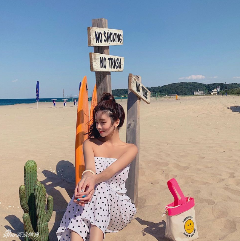 网红运动达人站在泳池边，阳光照射在她玲珑有致的身材上，她自信地撩动秀发，水滴顺着健康的小麦色肌肤滑落，画面充满健康活力的美感。