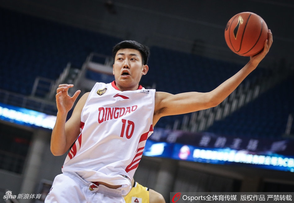 青岛队本土核心张骋宇面对防守球员，高高跃起干拔三分，篮球出手瞬间，他的眼神充满自信和坚定