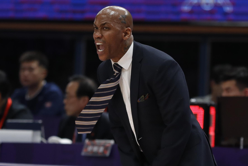 奥体中心夜色下，北控男篮与上海队的激战正酣，场上球员奋力拼抢，背景是座无虚席的看台，气氛紧张热烈