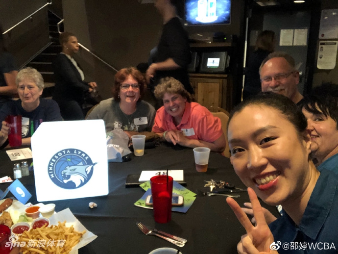 邵婷在签名桌后俯身，正专注地为一位小球迷手中的篮球签名，脸上带着温柔的笑意，仿佛将那份来自中国的亲切与热情，传递给了明尼苏达的每一位拥趸。