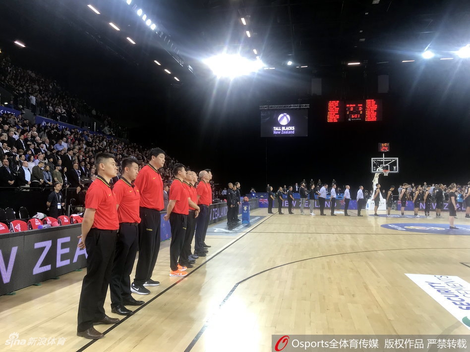 中国队核心易建联持球强行突破，他面前是两名新西兰高大的防守球员，整个画面充满了激烈的身体对抗和窒息的比赛氛围。