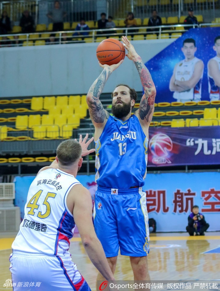 天津队老将张智涵高高跃起，在空中与肯帝亚防守球员发生身体对抗，依然坚定地将球投向篮筐。