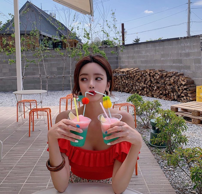 她扎起清爽的头发，身穿运动背心展示健康的小麦色肌肤和紧实的身体线条，充满了阳光活力的气息。