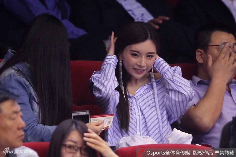 微风拂过她的长发，她抬起手轻轻整理，眼神中透着一丝温柔与专注