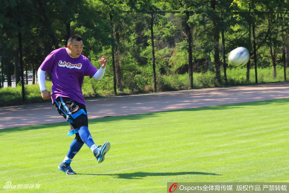 韩德君在球场上张开双臂奋力奔跑，庞大的身躯在绿茵场上显得格外有喜感，他正努力用不熟练的脚法追赶着皮球。