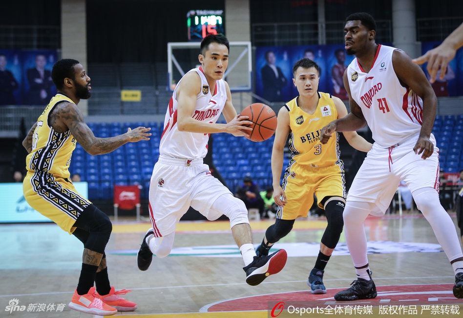 青岛与北控球员在赛场上激烈拼抢，篮球在空中划过一道弧线，双方队员的眼神都紧紧锁定球的轨迹