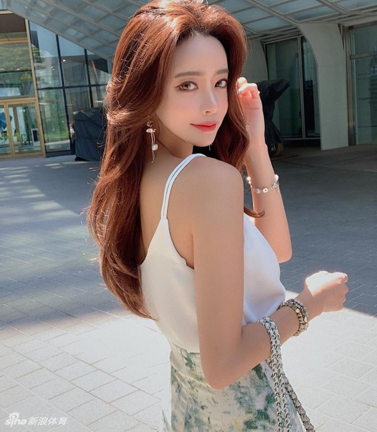 博主身穿亮色比基尼坐在泳池边，双手向后支撑身体，展现出优美的肩颈线条和自信的姿态，背景的棕榈树更增添了度假风情。