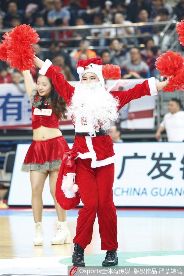 这位篮球宝贝双手轻托腮帮，歪着头露出俏皮甜美的微笑，宛如从童话中走出的圣诞少女。在紧张激烈的比赛间隙，她的笑容融化了每一位球迷的心。