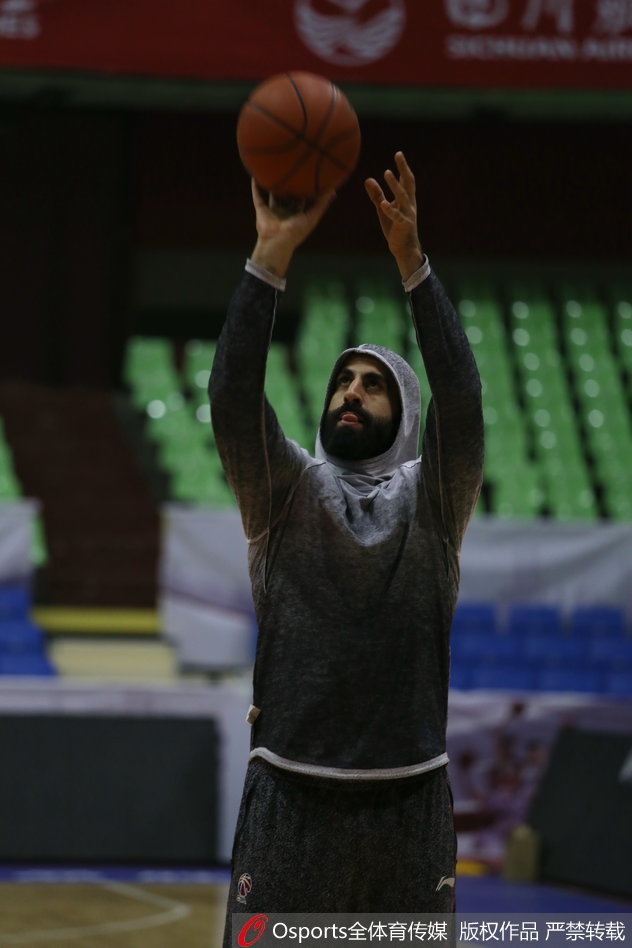 广州队核心后卫在训练中眼神坚毅，汗水浸透球衣，正组织队友进行战术演练。