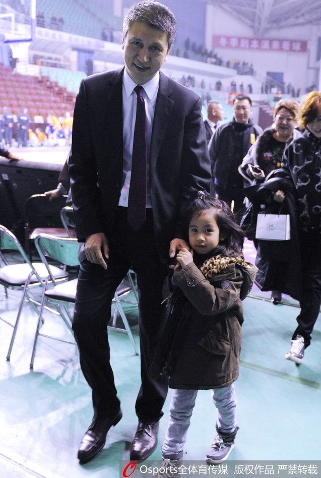 面对镜头，小姑娘显得有些害羞，小手紧紧抓着父亲的大手，而郭士强则微微侧身，用身体护着女儿，脸上露出温暖而憨厚的笑容，与赛场边指挥时的严肃表情判若两人