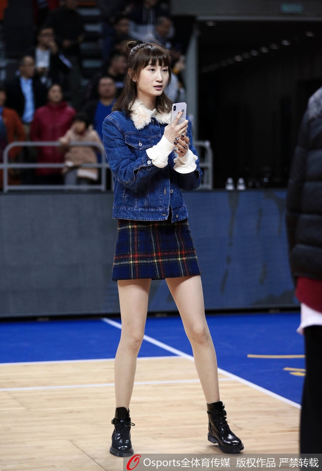 周鹏妻子刘美身着一袭时尚装扮，那修长身姿与温柔眼神，成为了东莞体育馆看台上最动人的风景。