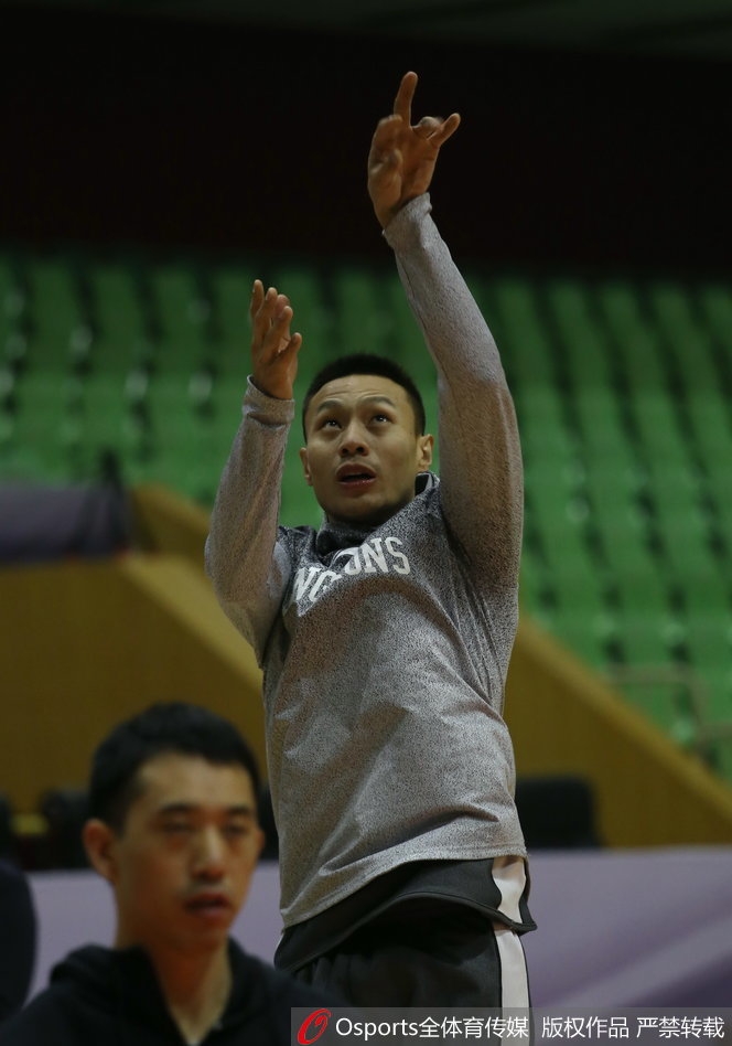 训练场上，广州队内线球员正在进行背身单打练习，教练员在一旁大声指导动作要领。